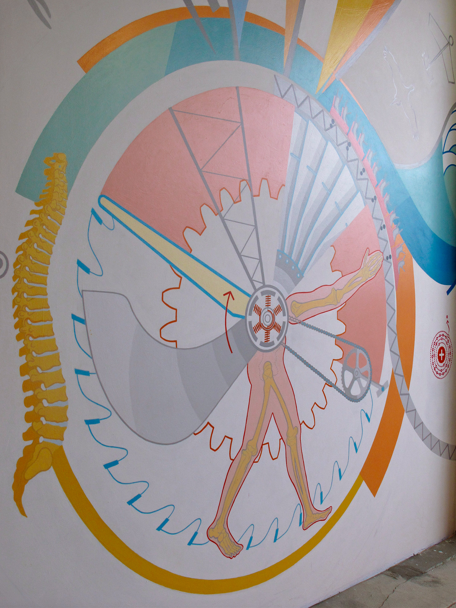 Zoom in on central round part of mural where things rotate around a motor, from a side view: 
                                                a turbine blade, a truss, the blades of a jet engine, an arm, a bike gear, legs, and a propeller plane blade.
                                                A big human spine is one the right, and a gear and saw blade in the background. Colors are in the yellow, orange, pink, with a dash of blue.