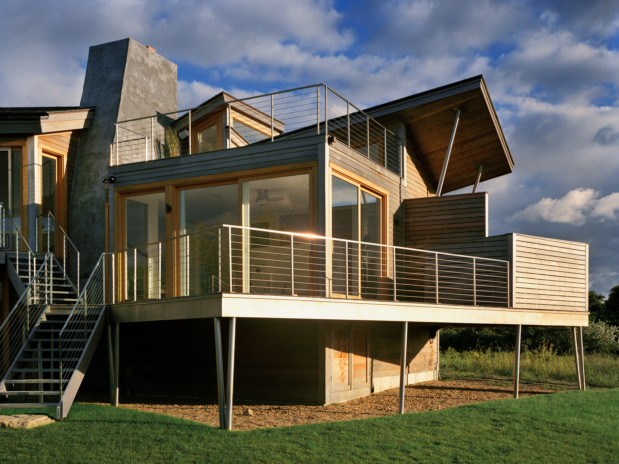 The master bedroom suite part of the house looks deconstructed, with angled projecting roof planes and decks both on top and around it.
