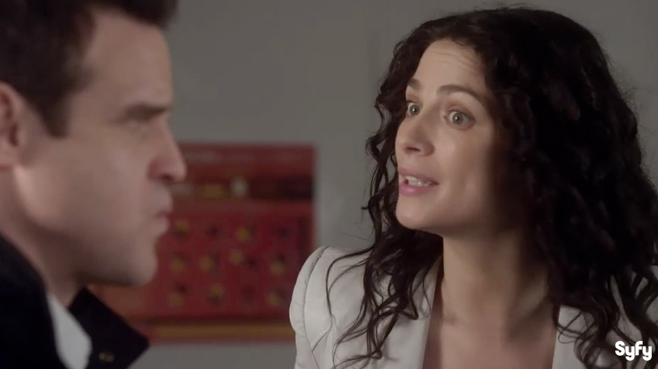 Blurry face of a white man listens to what white woman with black curly hair seems to say. 
                                                                                                An illustration on the MAILLARD REACTION is between them in the background, 
                                                                                                on the set of SyFy Network&rsquo;s Warehouse 13 &ldquo;Endless Wonder&rdquo; episode.