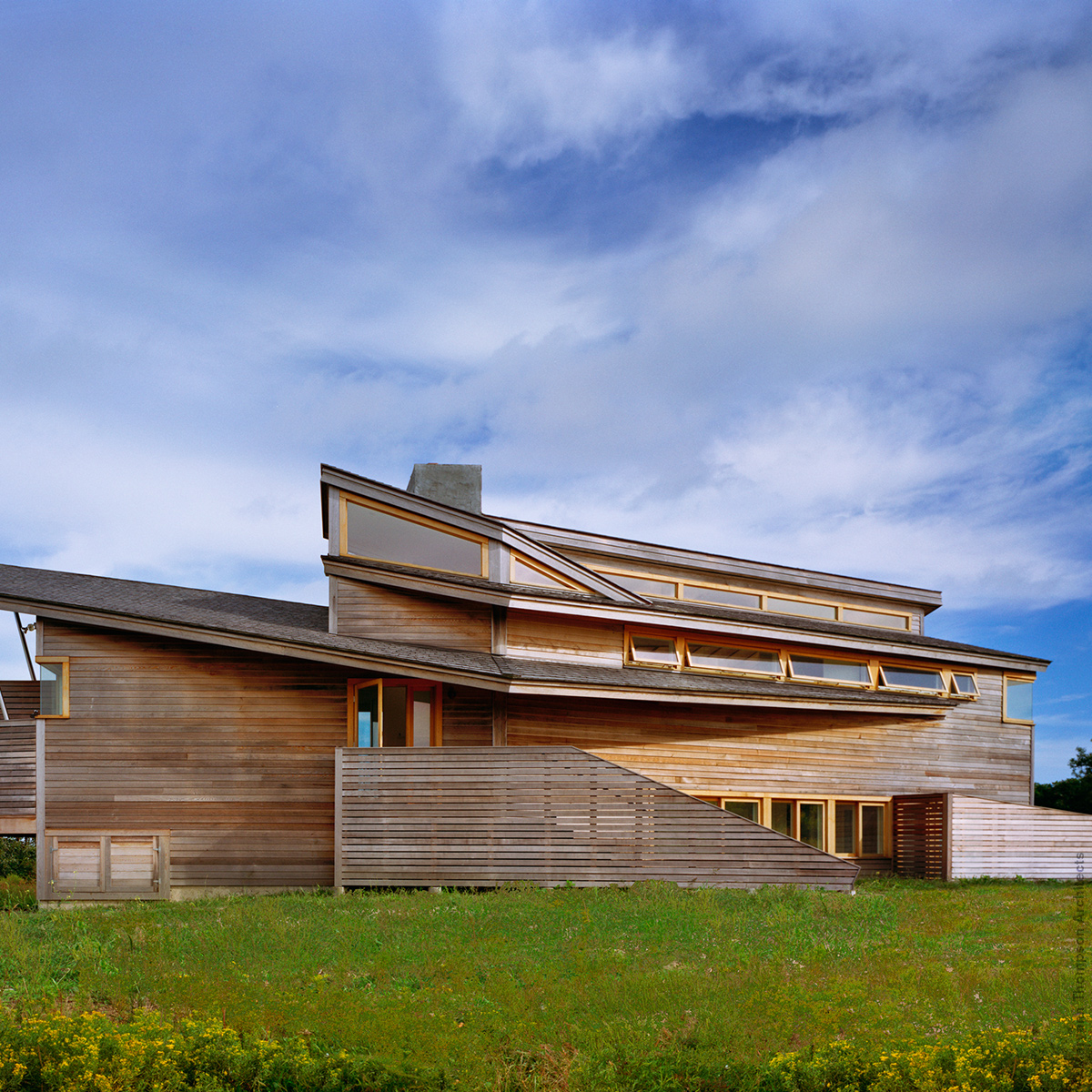 a modern cedar wooden siding house with angled roofs and walls cut at angles, on Martha’s Vineyard