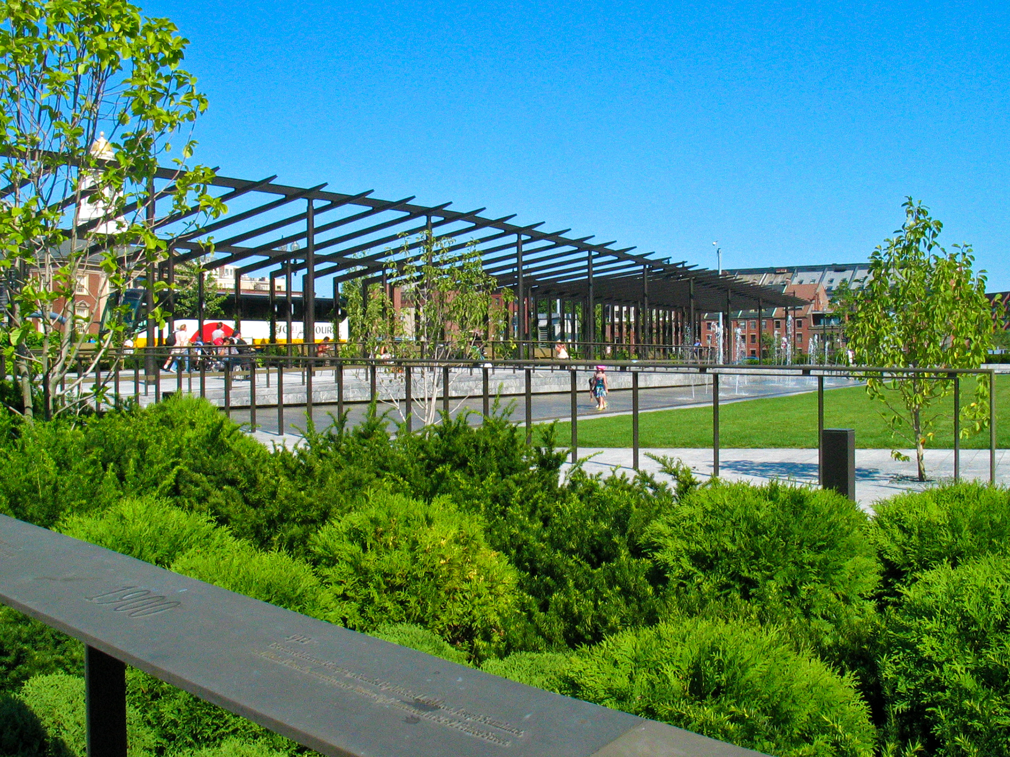 Big steel pergola painted dark brown, changes rhythm and curves as it goes up and down vertically. 
                                                        It looks elegant against in its very lush green park setting,
                                                        because it is made of long, but proportionally thin, structural members.